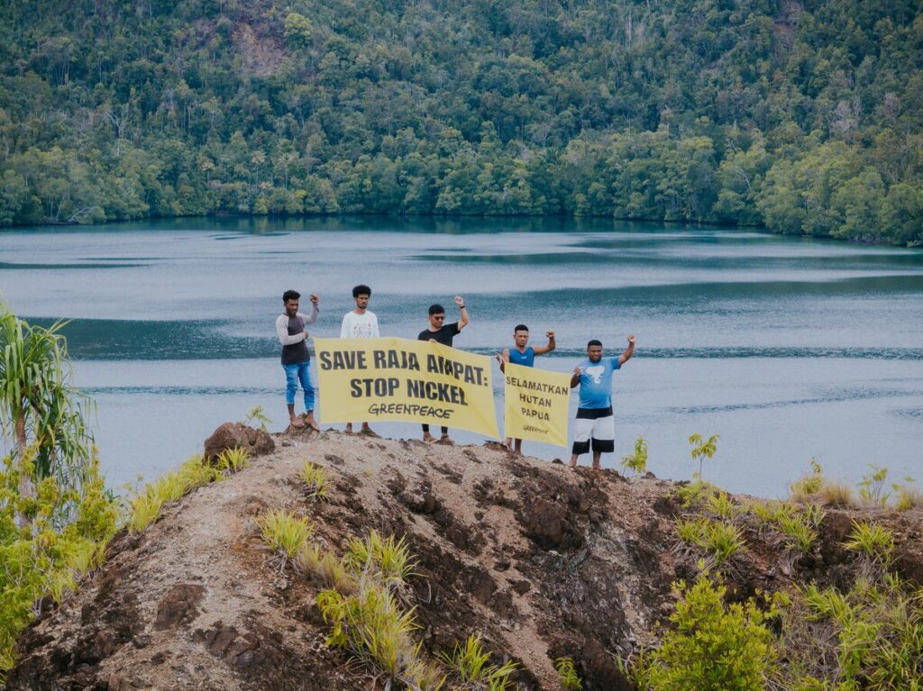 Residents of Manyaifun Village, together with Greenpeace Indonesia activists, posed for a photo with a banner reading ‘Save Raja Ampat, Stop Nickel’ and ‘Selamatkan Hutan Papua’, with Manyaifun Village and the hills of Batang Pele Island in the background.