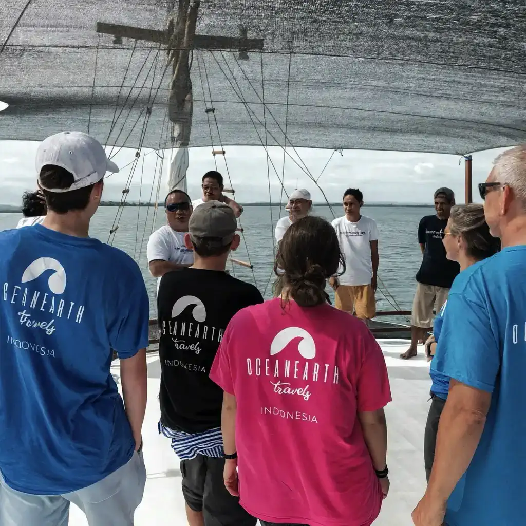Ocean Earth Travels team briefing with local guides on a liveaboard trip in Indonesia, promoting responsible and sustainable travel practices.