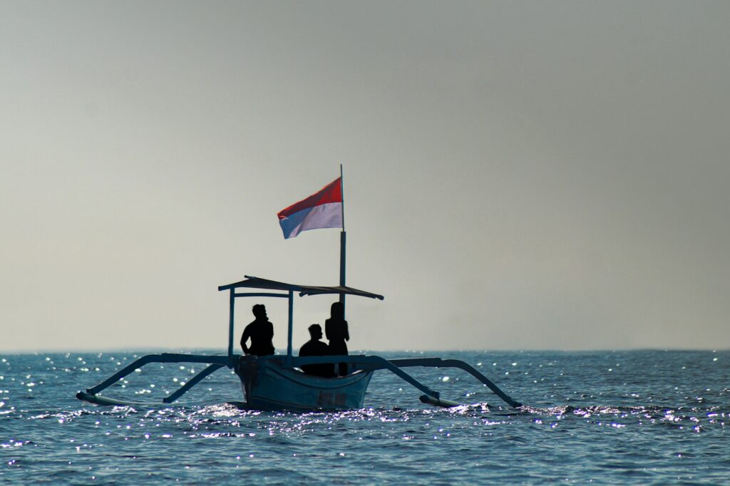 Indonesian flag raised on a Balinese junkung, a traditional fishermen's boat