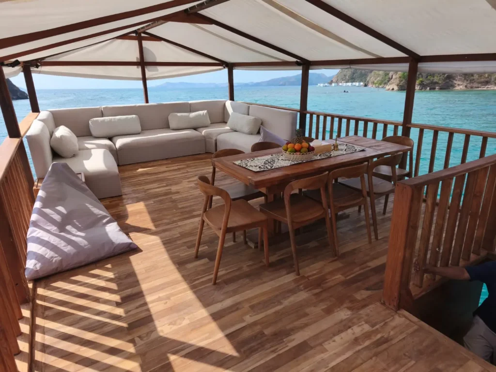 Lounge and dining table on the upper deck of Putri Naga, open on all sides