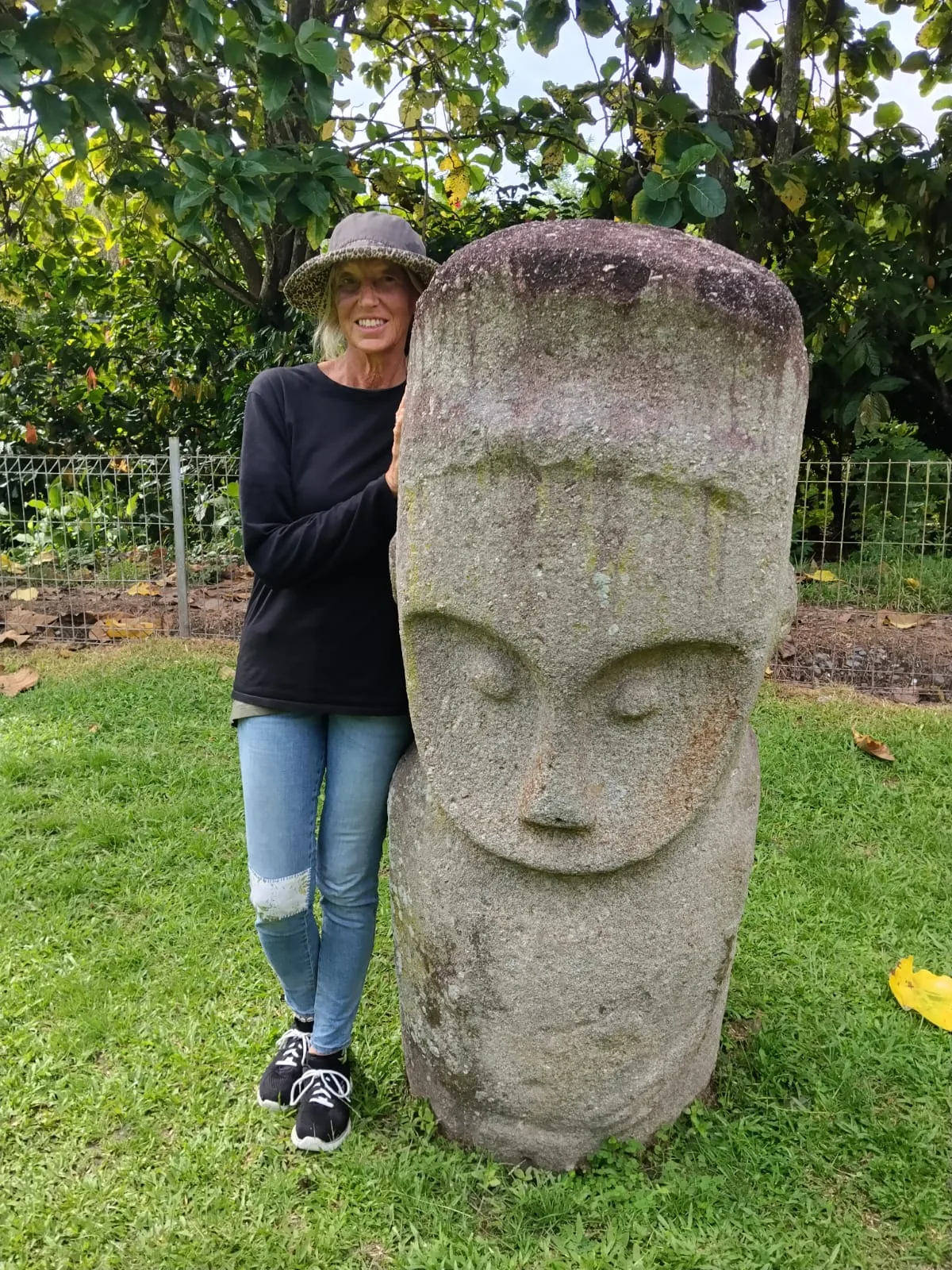 A traveller beside an ancient megalith in the Bada Valley, Sulawesi