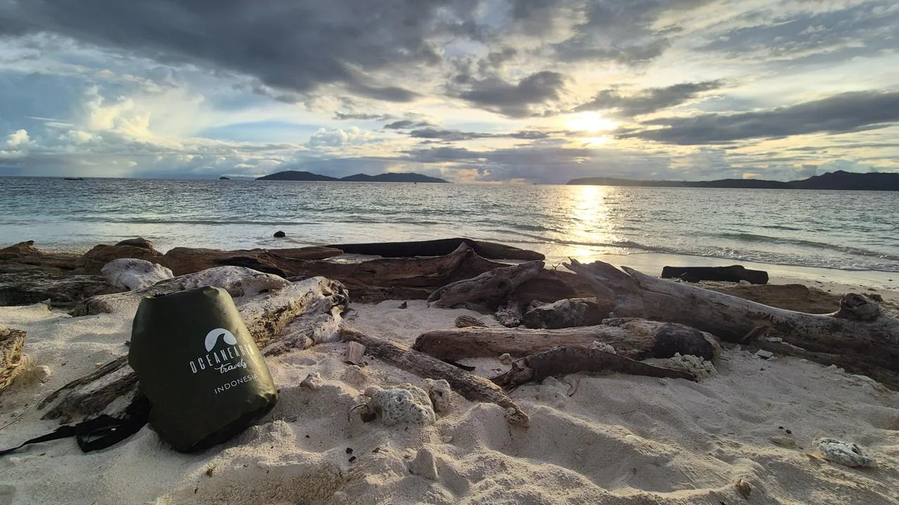 Sunset over a white-sand beach in Raja Ampat