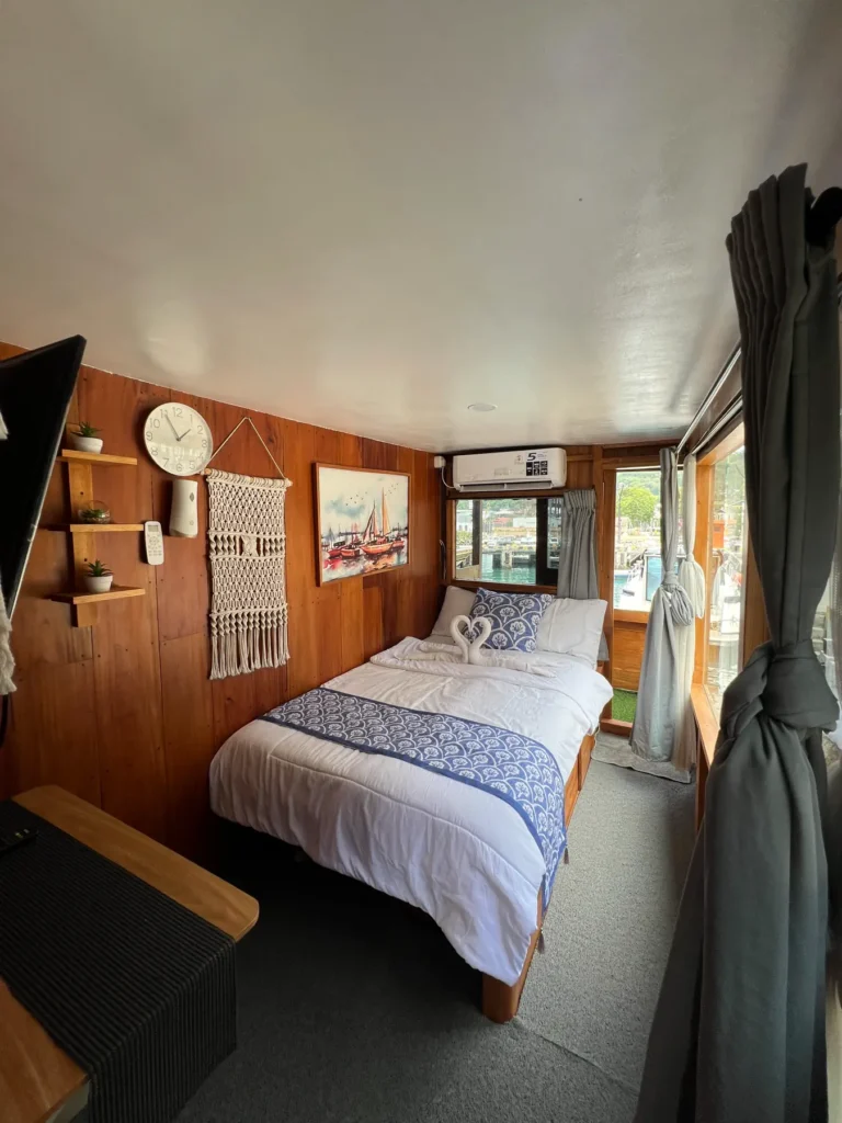 Double bed and window in a master cabin on Dinara