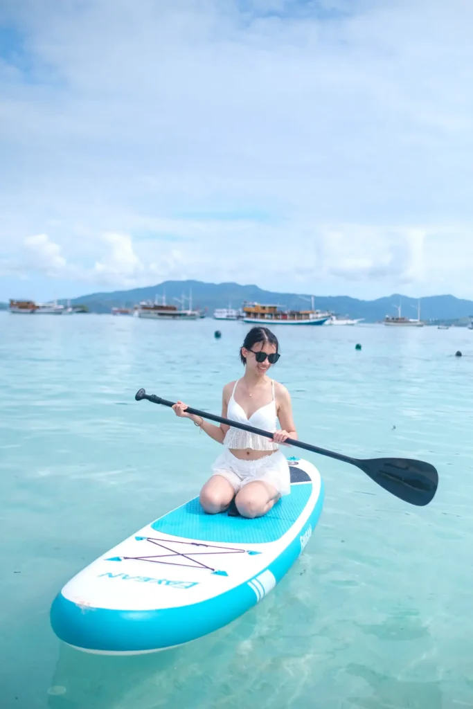 Guest on a paddleboard beside Dinara