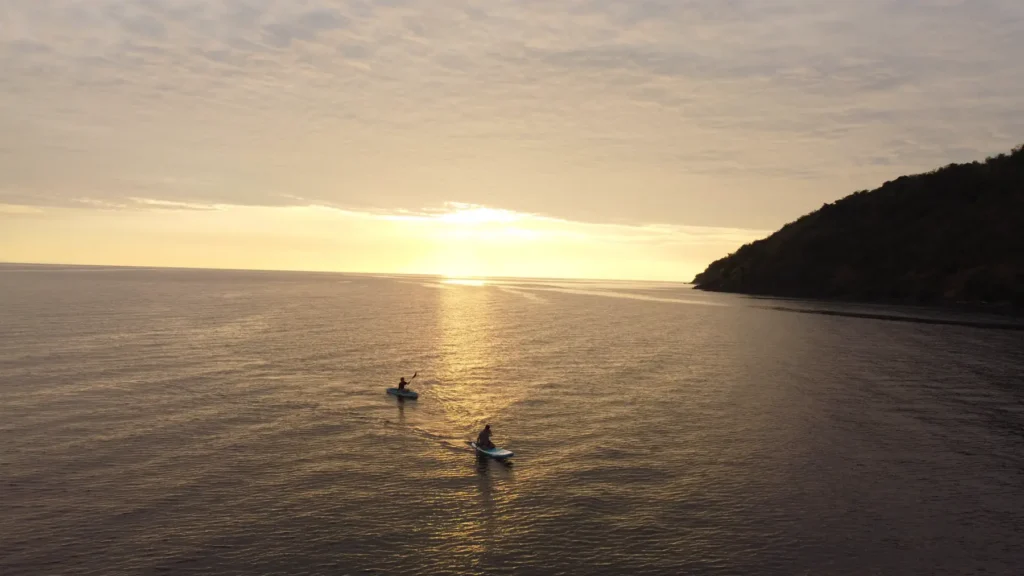 Paddleboarder at sunset near Dinara in Komodo
