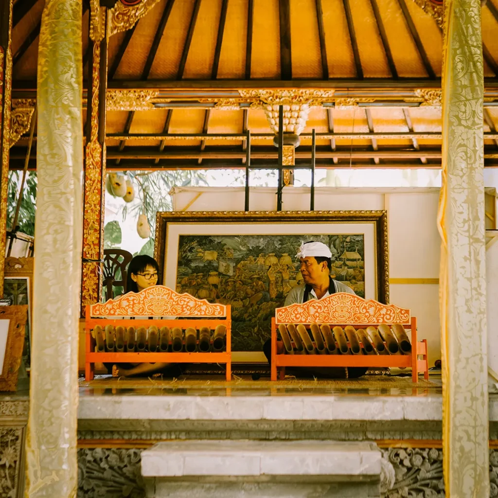 Musicians playing rindik bamboo instruments in a pavilion at ARMA Museum