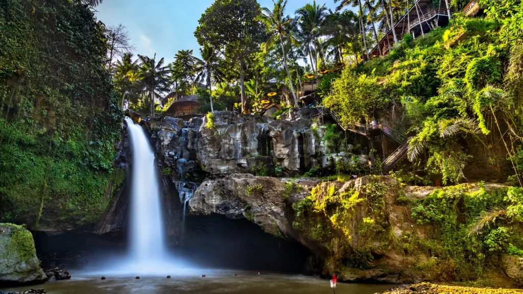Tegenungan Waterfall dropping into a pool surrounded by jungle