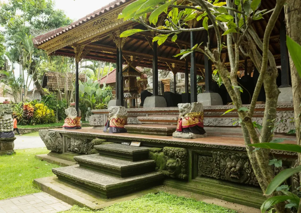 Raised pavilion with stone guardian statues in the garden of Ubud Palace