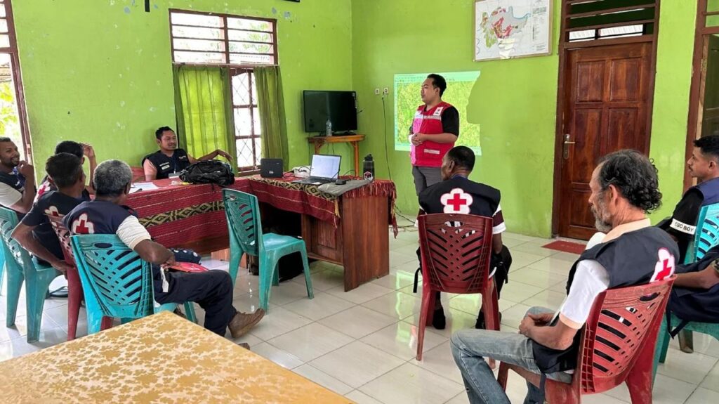 Indonesian Red Cross volunteers in vests at a relief coordination meeting in Flores