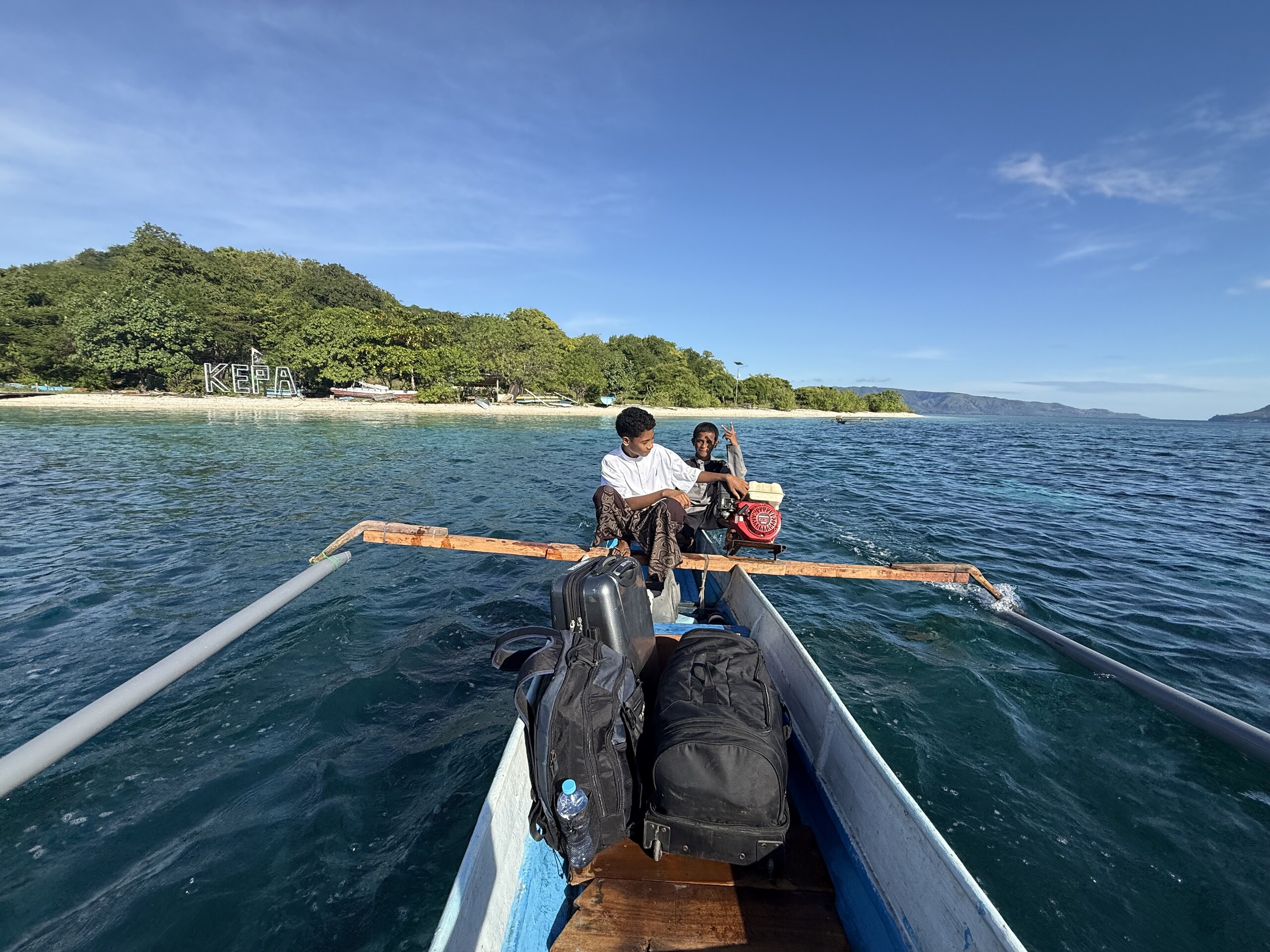 A local outrigger boat crossing from Kepa island with the boatman at the stern