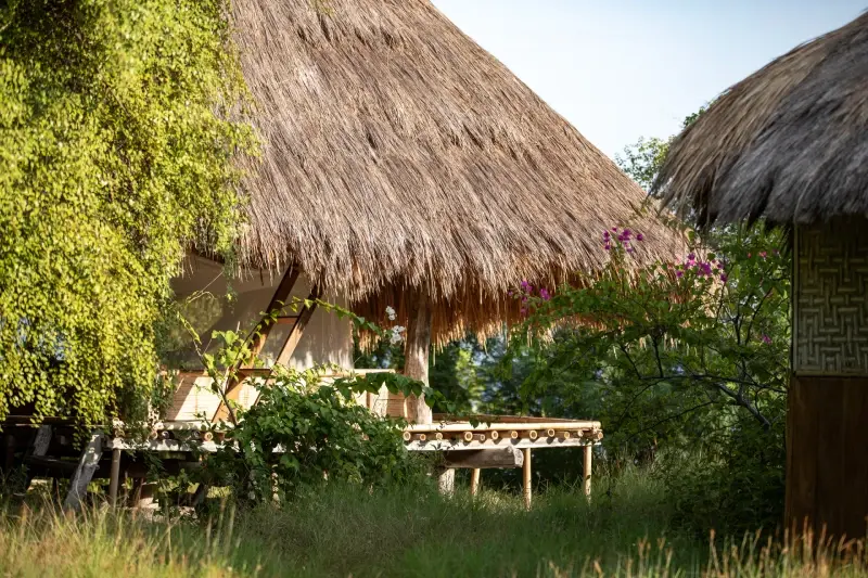 A traditional hut with a thatched roof in the garden at La P'tite Kepa