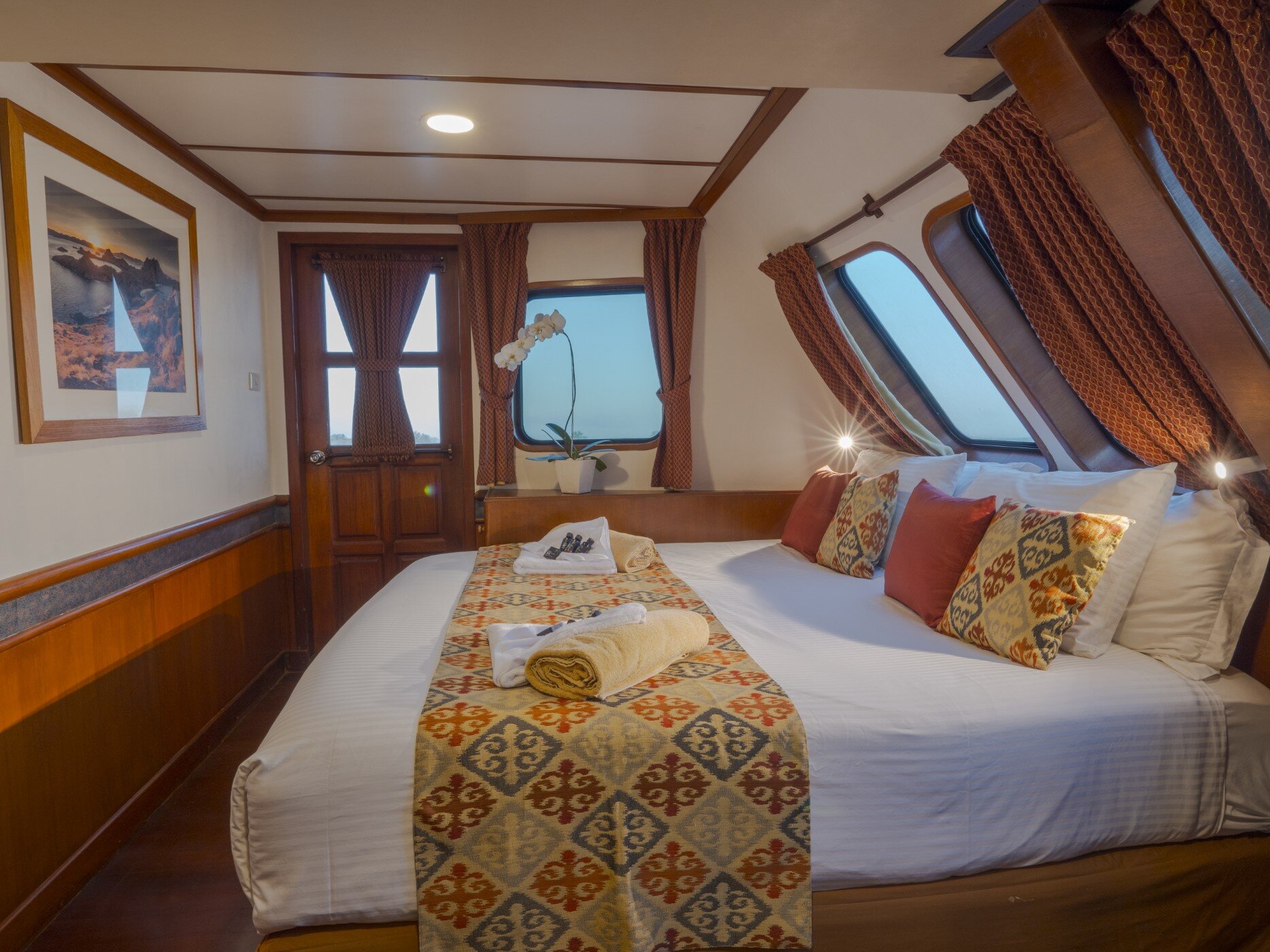 Second view of the Mermaid I master cabin showing the bed, framed artwork and portholes