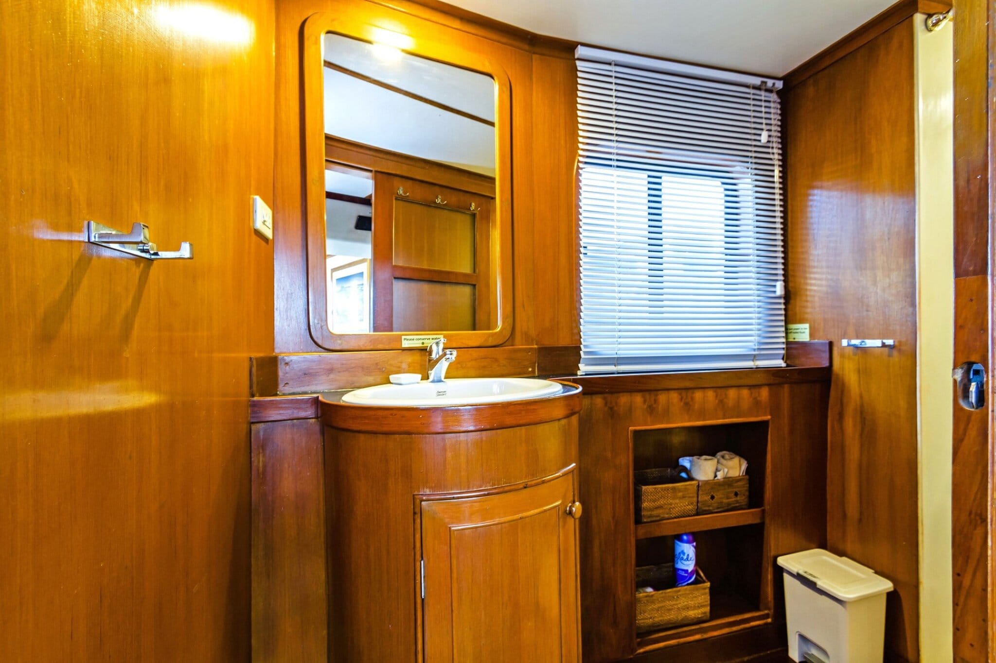 Ensuite bathroom in the Mermaid I master cabin with a basin, mirror and wood cabinetry