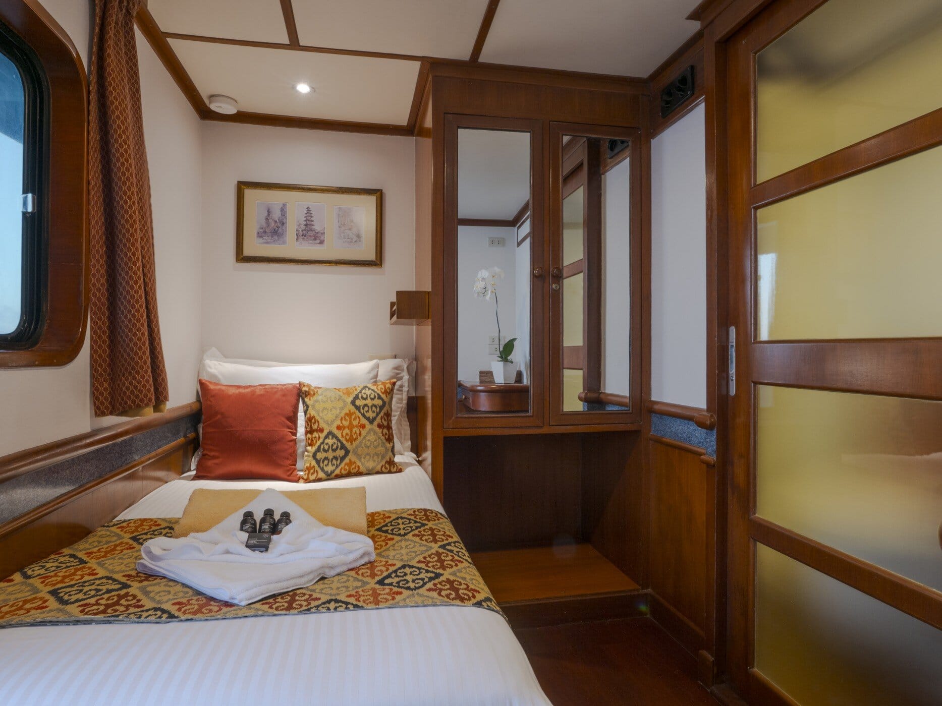 Single cabin on the Mermaid I with one bed, a porthole and a wardrobe