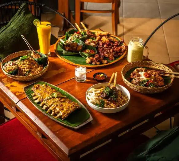 Ribs, sate and side dishes on a table at Warung Pondok Madu