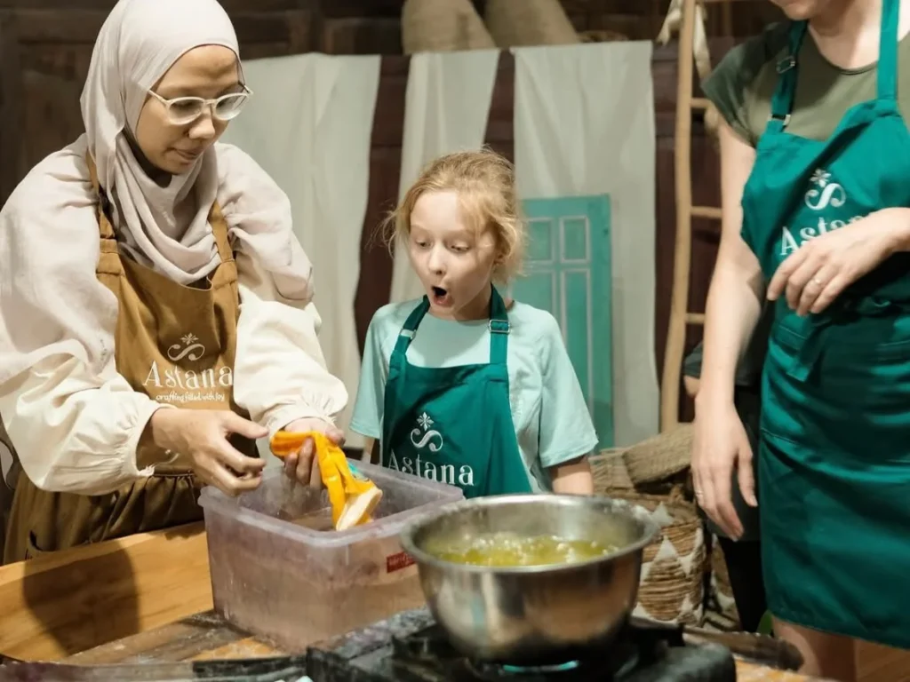 Instructor showing how to apply hot wax to cloth at Astana Workshop Batik