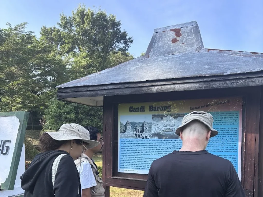 Visitors reading the information board at Candi Barong