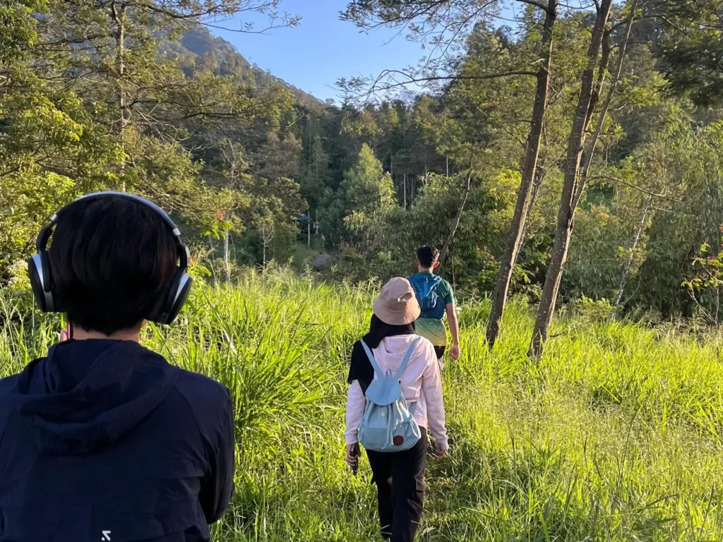 Walkers on a grassy trail at Deles Indah on the eastern slopes of Merapi