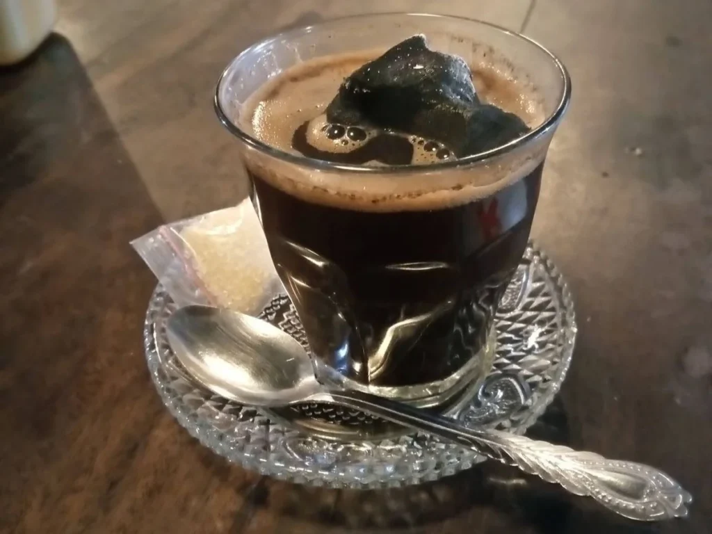 Kopi joss, coffee with a piece of glowing charcoal, at an angkringan in Yogyakarta