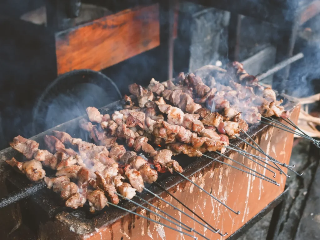 Sate klathak goat satay on bicycle-spoke skewers over the grill in Bantul