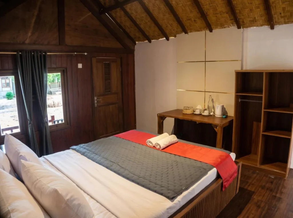 Double room at Maryan Moyo with a wooden floor and walls, air conditioning and a double bed