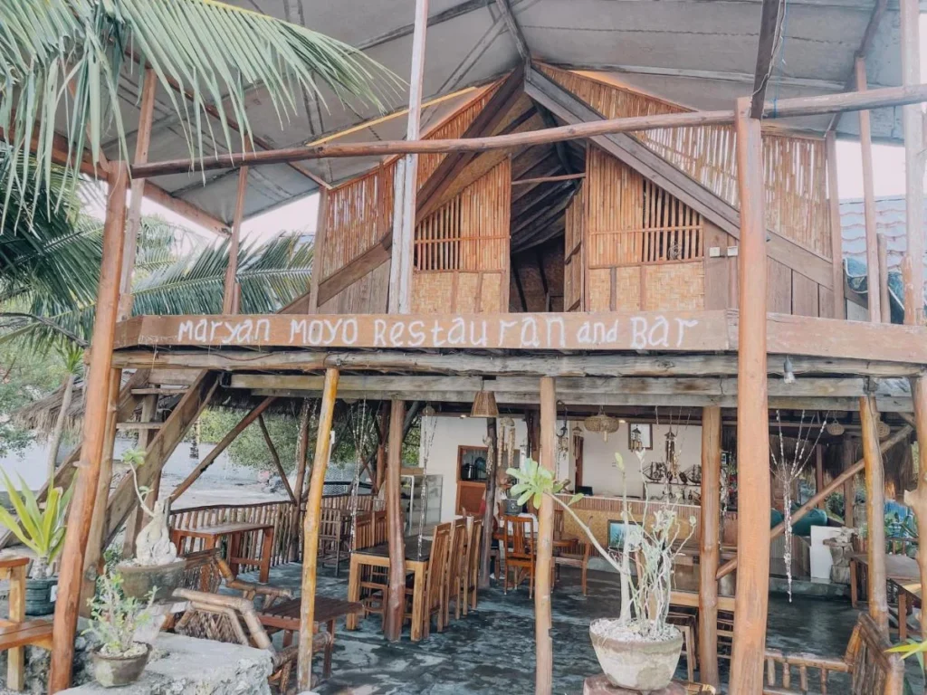 The open-sided wooden restaurant and bar at Maryan Moyo, raised on stilts under a palm roof
