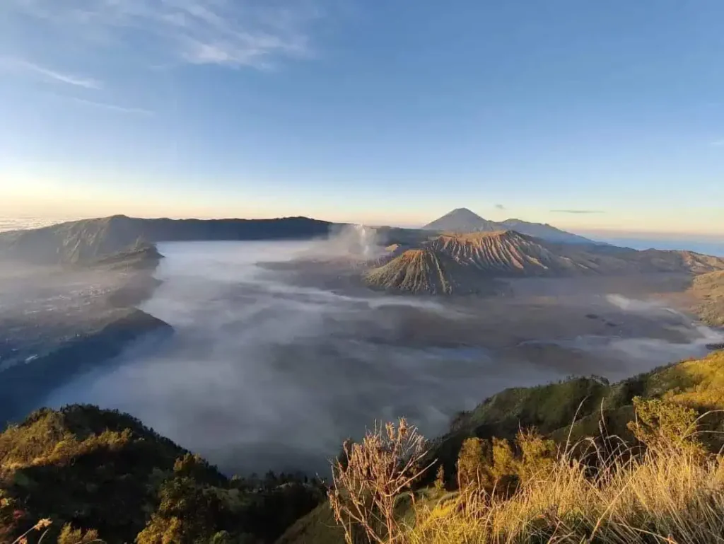 Mist filling the Tengger caldera at sunrise, with Mount Bromo smoking and Semeru behind