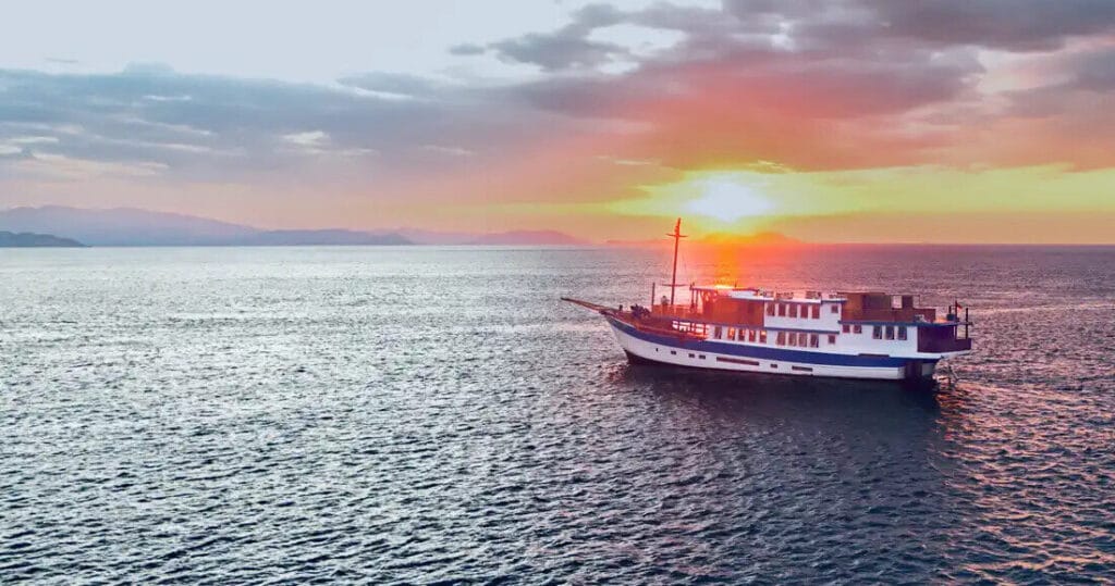 Naga Biru at sunset on a calm sea, seen from a distance