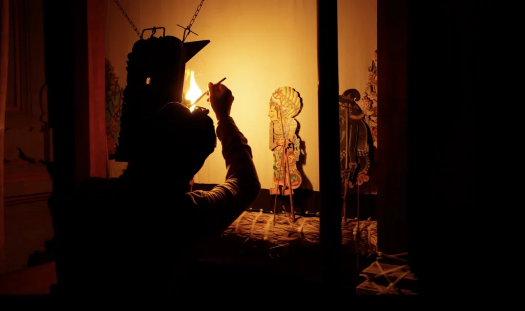 Le maître marionnettiste derrière l'écran pendant un spectacle de Wayang Kulit