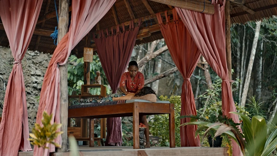 Massage table in the spa, framed by curtains and plants